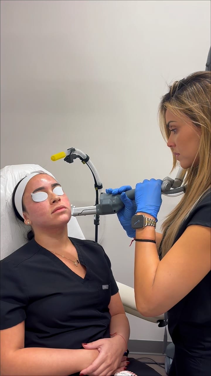 A provider treating a patient's face with a handheld laser