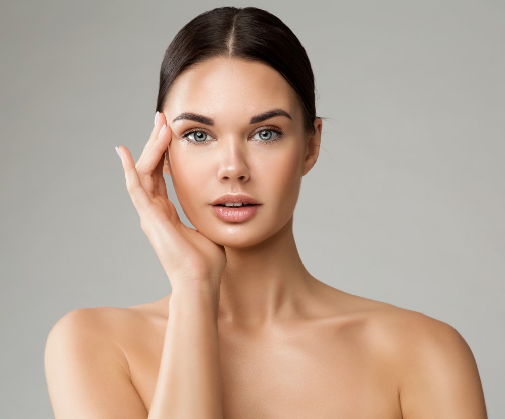 Model with smooth skin touching her cheekbone