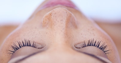Close-up of a model's closed eyes with long, full lashes