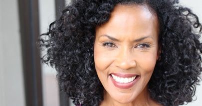 Smiling model with full curly dark hair
