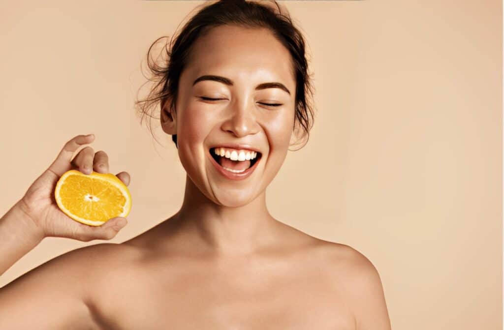 Smiling woman with radiant face skin and orange portrait.