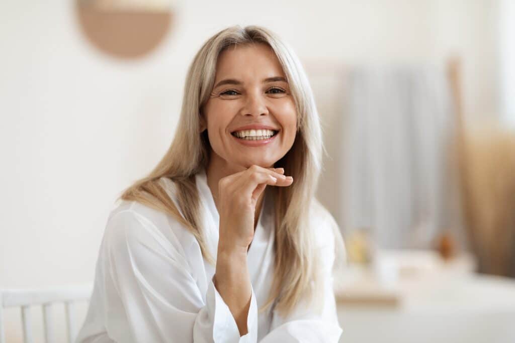 Woman with gray hair smiling at camera