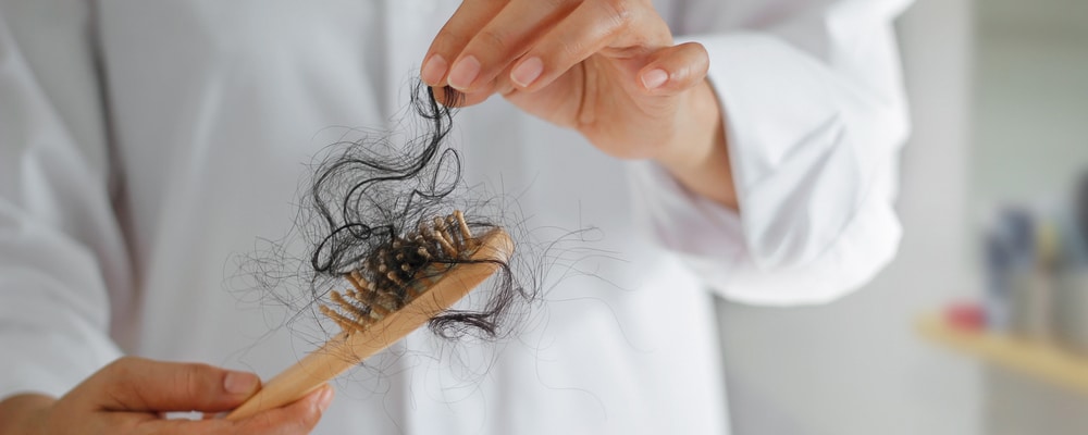 Woman,Losing,Hair,On,Hairbrush,In,Hand,,Soft,Focus