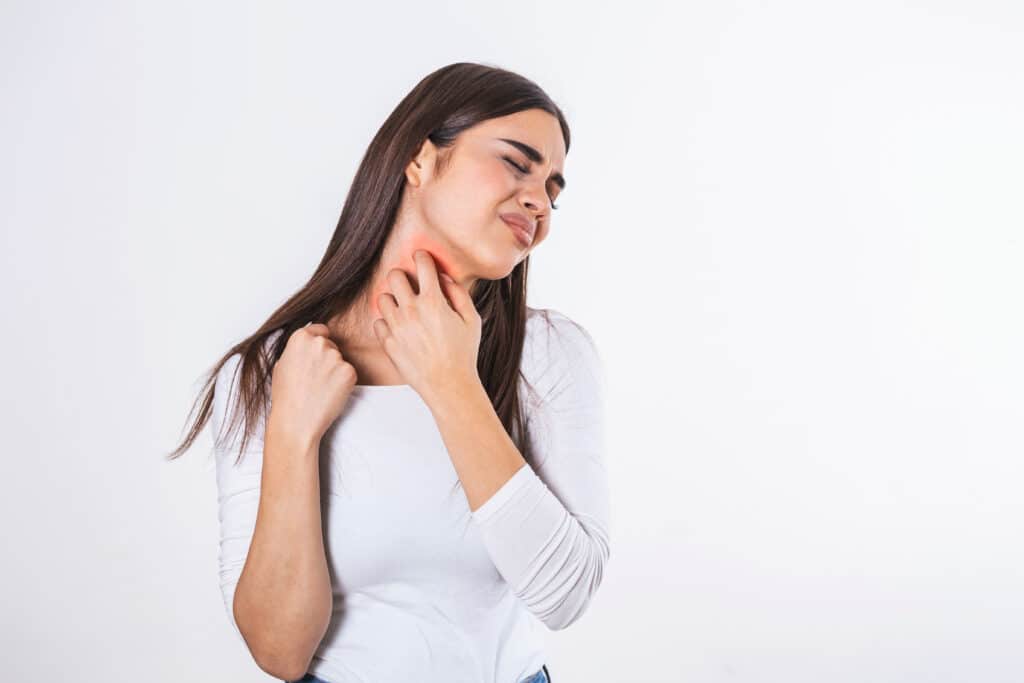 Woman with psoriasis scratching her neck and feeling uncomfortable.