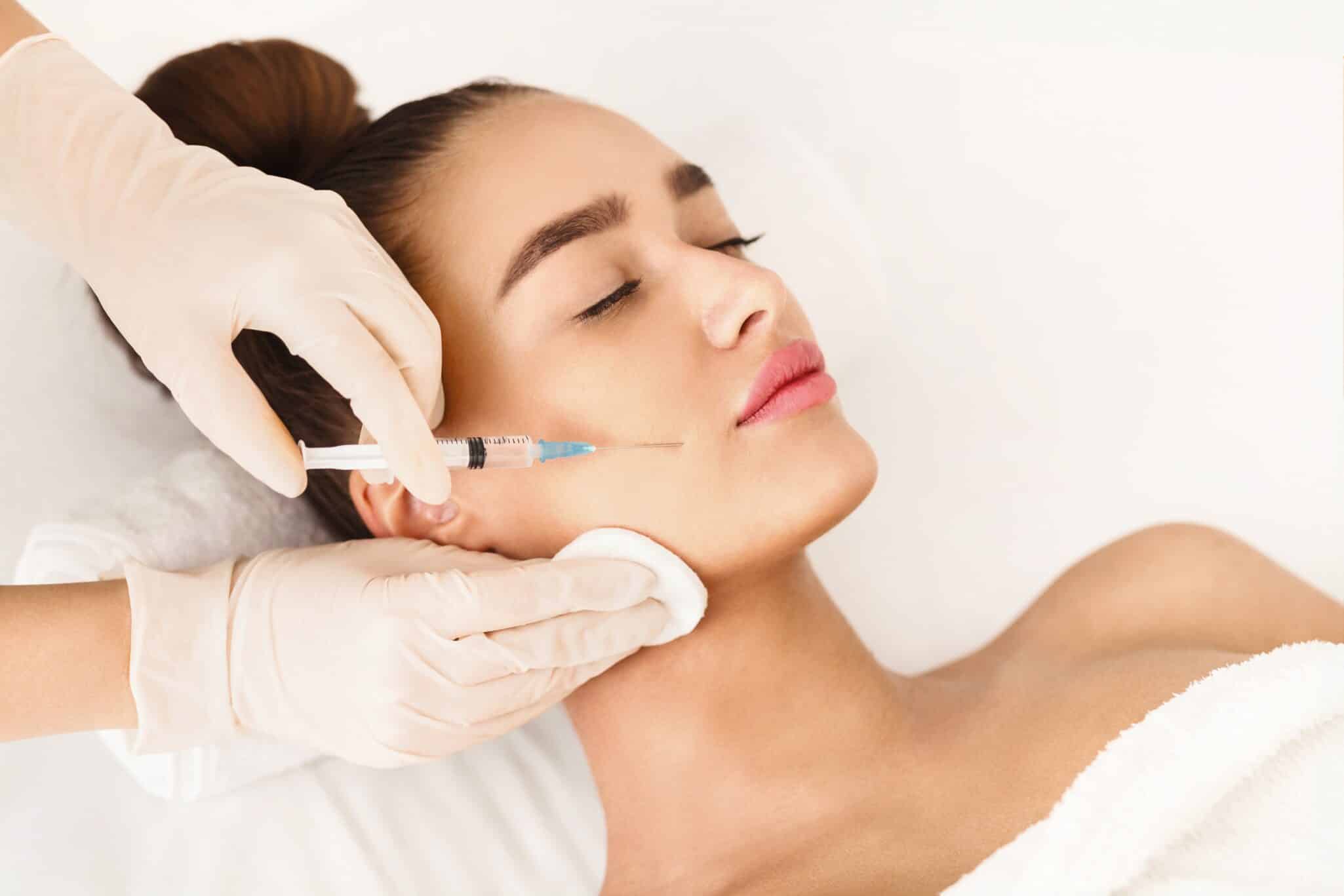 Beautiful woman receiving Jeuveau injections around her mouth to treat frown lines