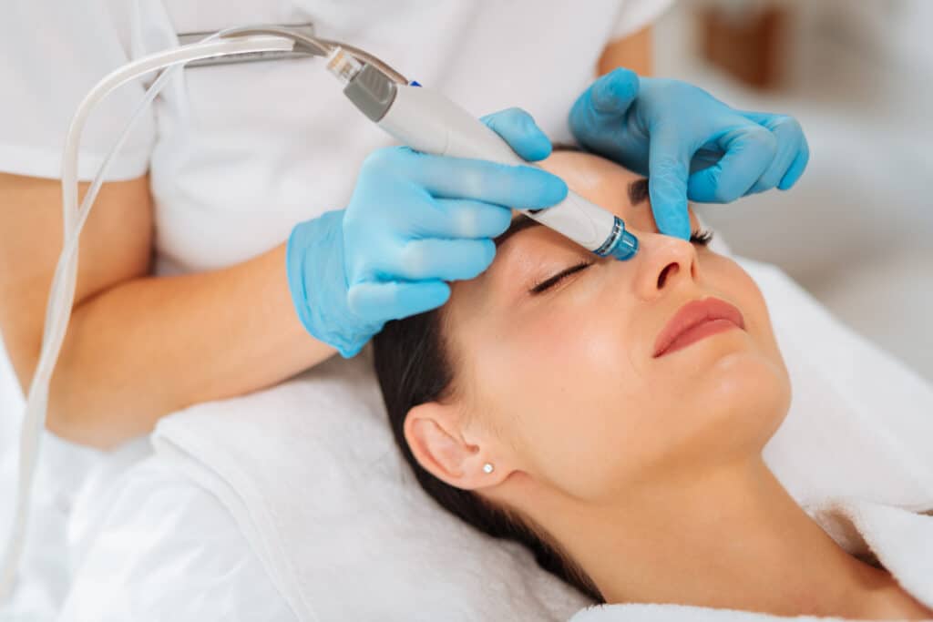 Close up of a woman getting a Hydrafacial treatment by her dermatologist for smoother, brighter skin