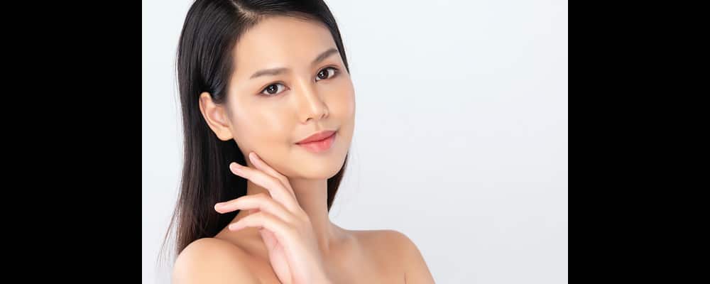 Beautiful young woman with shiny, glassy skin after getting Glassifier skin treatment.
